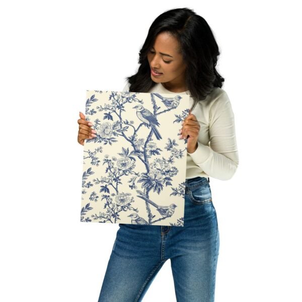 woman holding Decorative metal print showcasing vibrant blue songbirds amidst pink blossoms with detailed floral accents