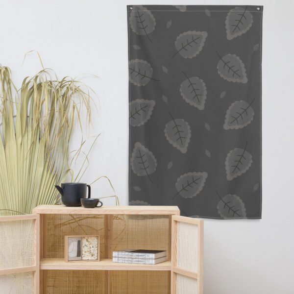 Wall tapestry featuring a leaf pattern in shades of gray on a dark background.