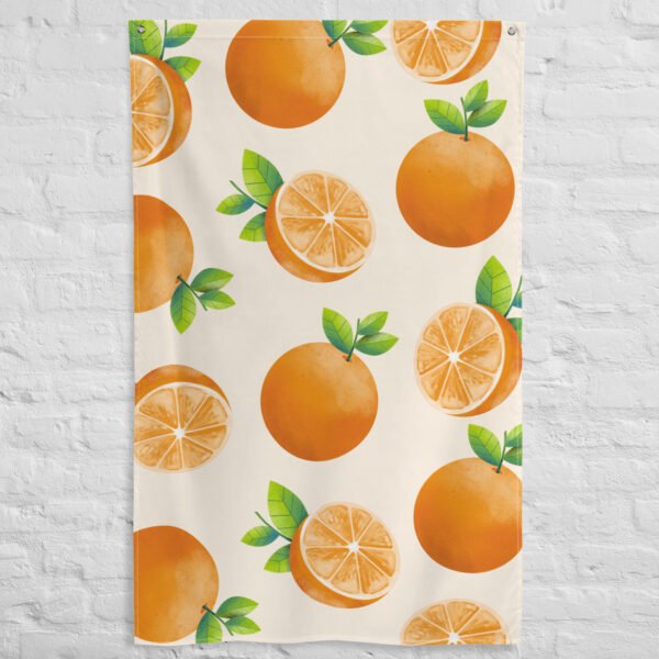 The Orange fruit pattern tapestry wall hanging, featuring a beige cloth with whole oranges and orange halves with green leaves, hangs against a white brick wall.