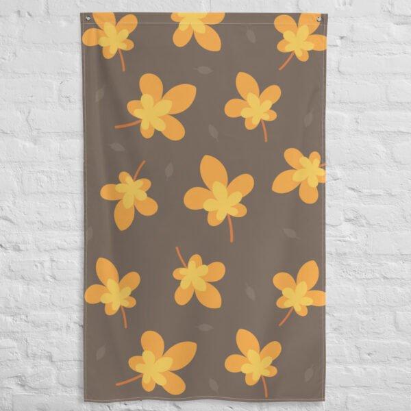The Yellow leaf pattern tapestry hangs on a white brick wall, showcasing large yellow and orange stylized leaves with subtle gray leaves in the background.