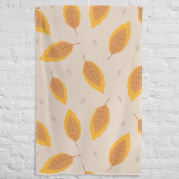 The Autumn leafs pattern tapestry is a beige fabric displayed on a white brick wall, showcasing orange and yellow autumn leaves with brown veins and small light beige leaves in the background.
