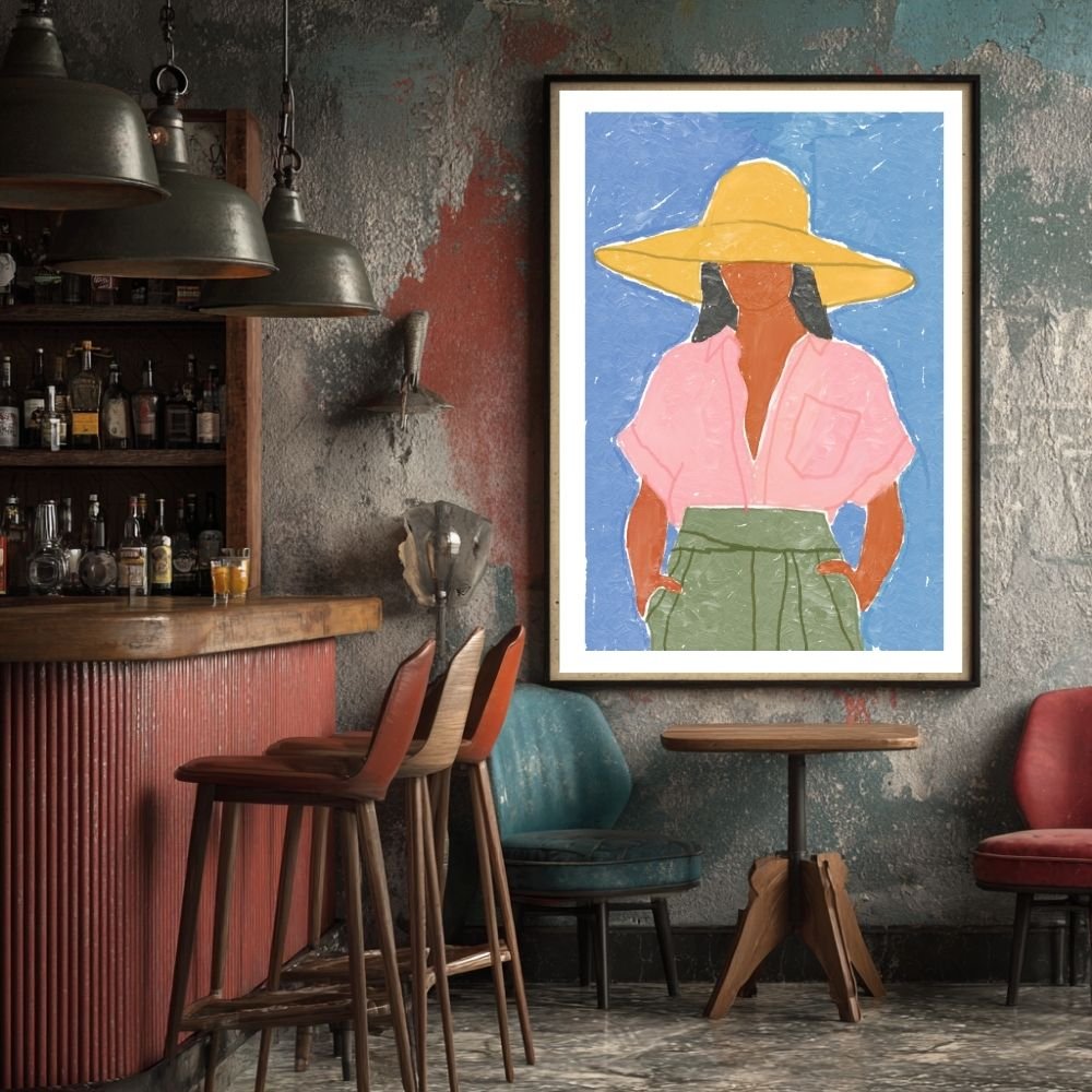 Framed artwork depicting a woman wearing a pink shirt and a large yellow hat against a blue background.
