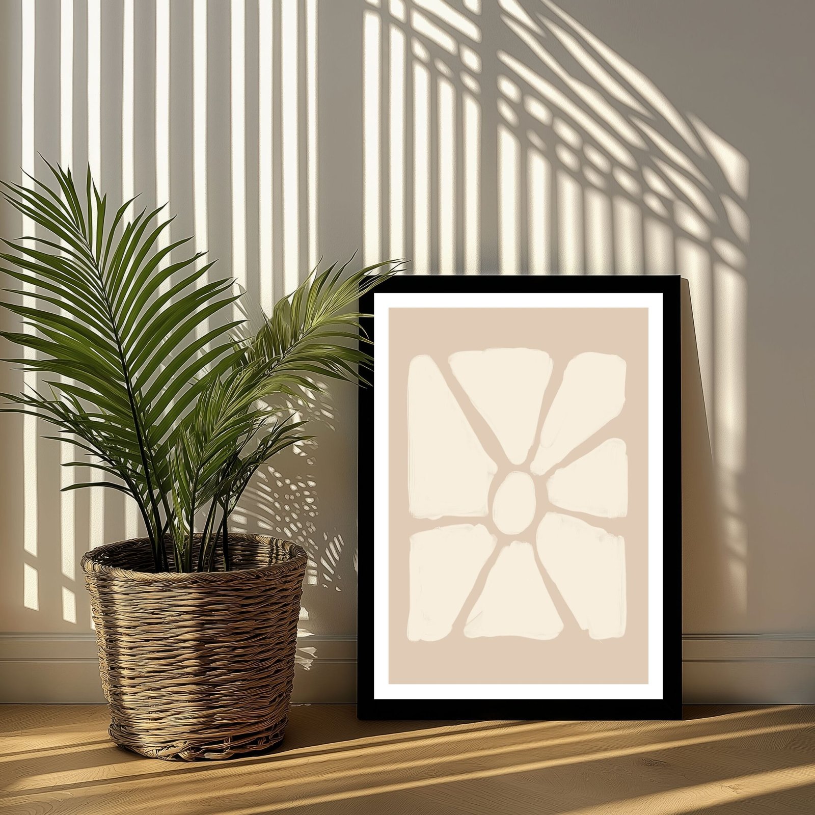 Framed abstract artwork featuring a floral design in neutral tones, placed beside a potted plant.