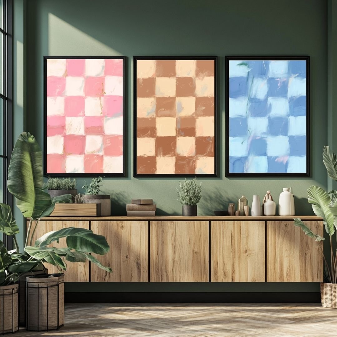 Three framed abstract checkerboard art prints in pink, brown, and blue displayed on a wall.