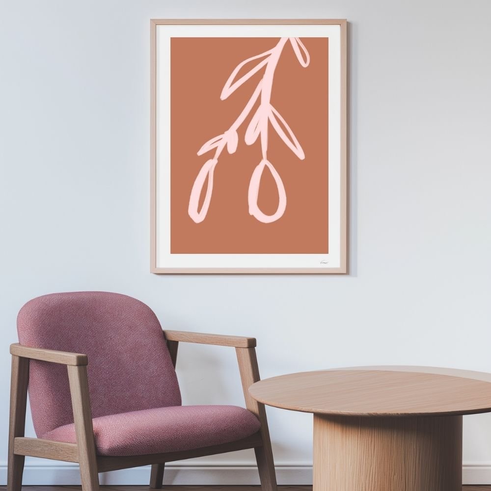 Framed abstract floral artwork featuring a pink branch on a terracotta background.
