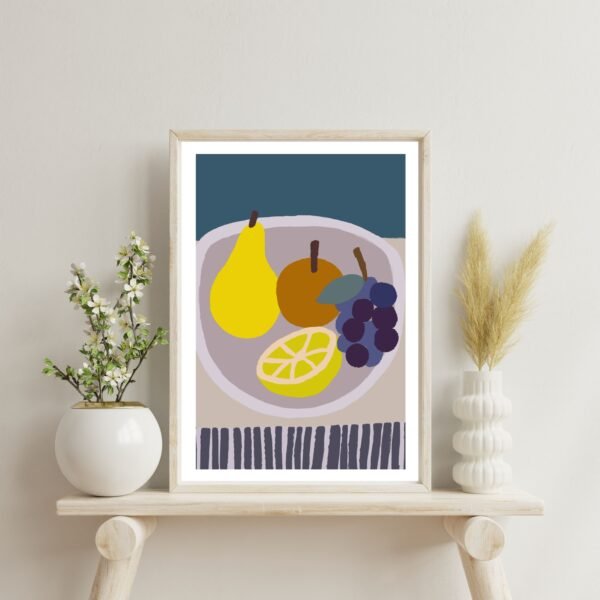 Framed artwork depicting a bowl of fruit including pears, grapes, and a lemon slice.